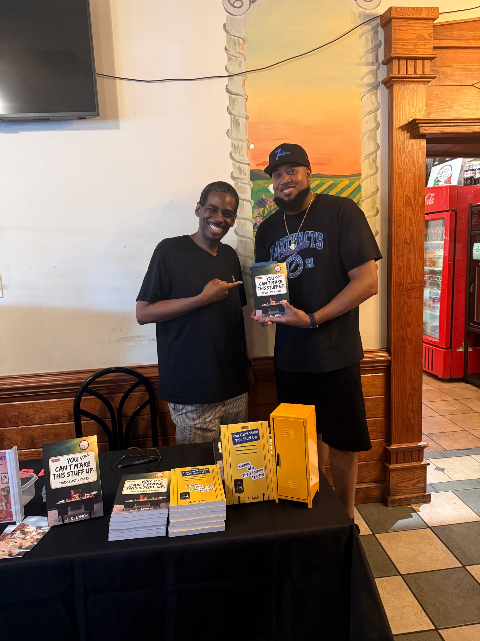 J.K. Lynch posing with a fan holding his book